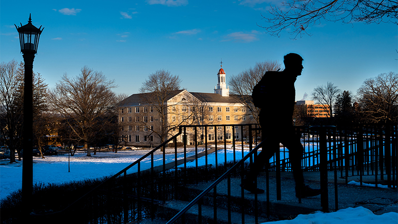 Silhouette of student against wintry campus