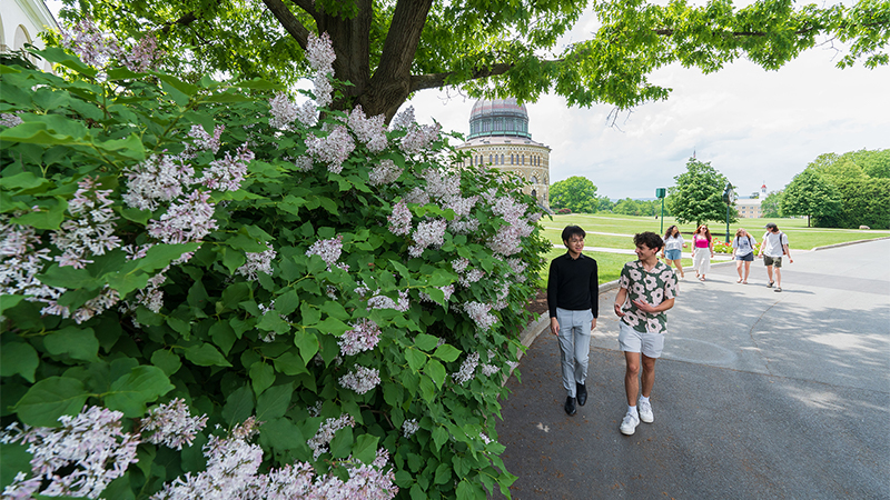 Outdoor spring photo of two students on campus